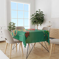 Green themed tablecloth draped on a dining table with colorful decorative border