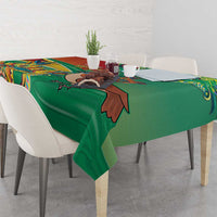 Green tablecloth with bird and floral motif, neatly spread across the tabletop