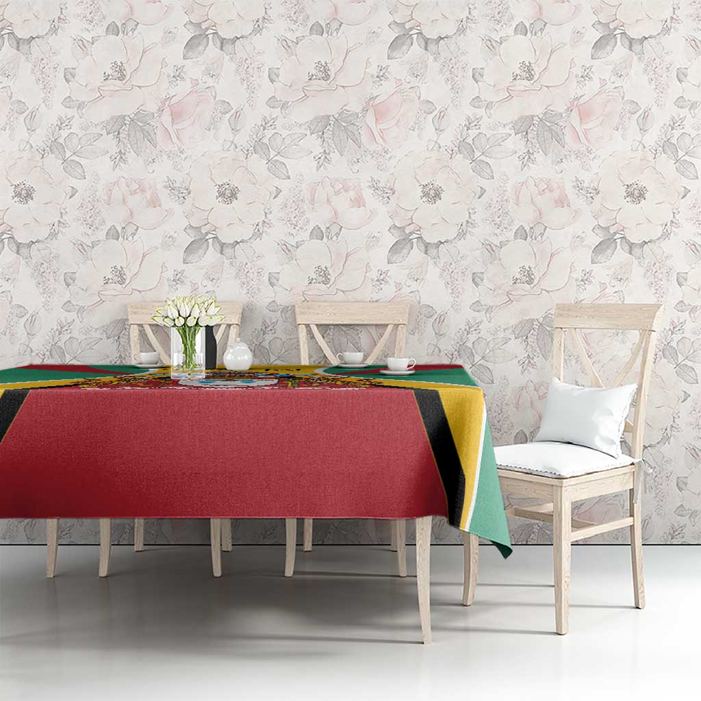 Guyana coat of arms tablecloth on dining table, red center and green sides with yellow accents