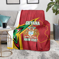 Red Guyana cricket blanket with crest and YOUR TEXT, draped over sofa cushion
