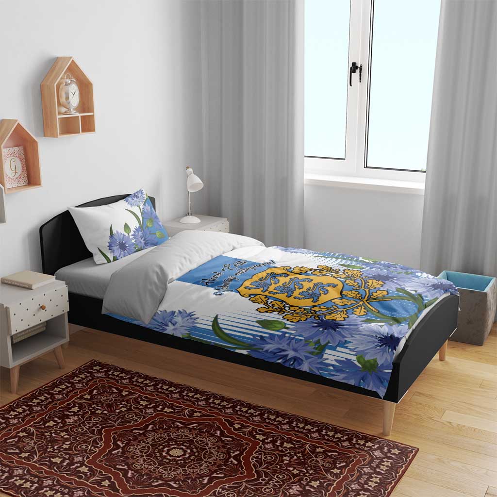 Blue duvet on bed with floral cornflower pattern and crest emblem, plus two pillowcases