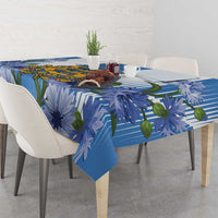 Blue tablecloth with stripe and blue flower print, draped over dining table