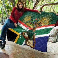 Green quilt laid out on a sofa with Springboks mascot, diagonal stripes, and quilted stitching.