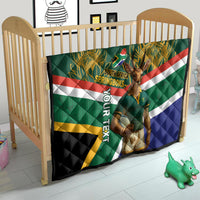 Green quilt in a crib with Springboks text, mascot graphic, and multicolor stripe design.