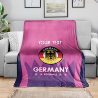 Pink Germany football blanket draped on a couch with "YOUR TEXT" and crest