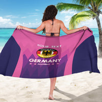 Pink and navy sarong held open showing Germany crest and 'YOUR TEXT' lettering
