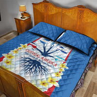 Blue quilt bed set with Central America emblem, flowers, and two black-trimmed pillow shams