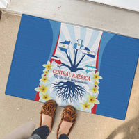 Blue rubber doormat with Central America slogan, flowers, and tree-root illustration