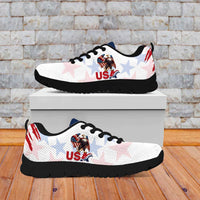 White lace-up sneakers on a box with USA eagle, red grunge stripe, black outsole.