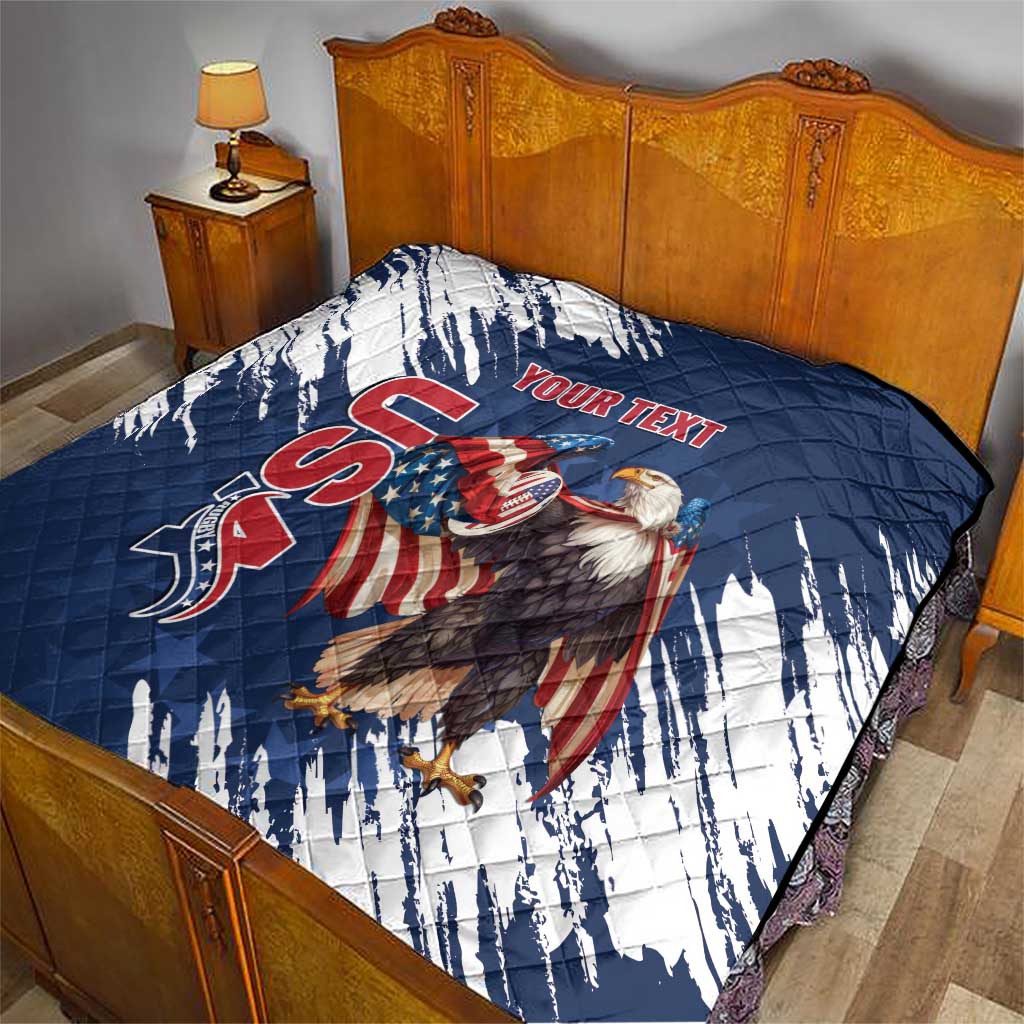 Blue and white quilt draped on bed, quilted design with eagle and red “YOUR TEXT”