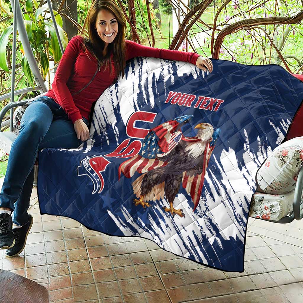Blue and white quilt held over couch, quilted pattern with eagle graphic and “YOUR TEXT”