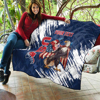 Blue and white quilt held over couch, quilted pattern with eagle graphic and “YOUR TEXT”