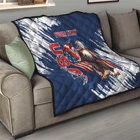 Blue and white quilt on gray sofa, quilted stitching with eagle graphic and red “YOUR TEXT”