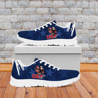 Blue low-top sneakers with USA eagle emblem, white brush marks, and white outsole