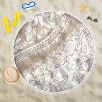 Beige round beach blanket with white tropical flower and palm pattern, fringed edge