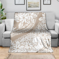 Beige and white tropical floral print blanket, spread over a sofa