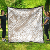 Beige tropical floral quilt with white print, diamond quilting, black border on all sides.