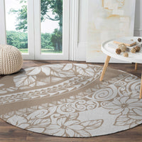 Beige round area rug with white tropical flowers, leaves, and geometric motifs