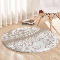 Round area rug with beige ground and white tropical leaf and flower outline