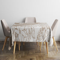 Beige and white tropical botanical tablecloth with leaf and scroll print over round table