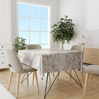 Beige and white tropical floral tablecloth covering dining table, leafy pattern