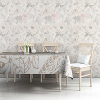 Beige and white botanical tablecloth with leaf and flower print, spread over tabletop