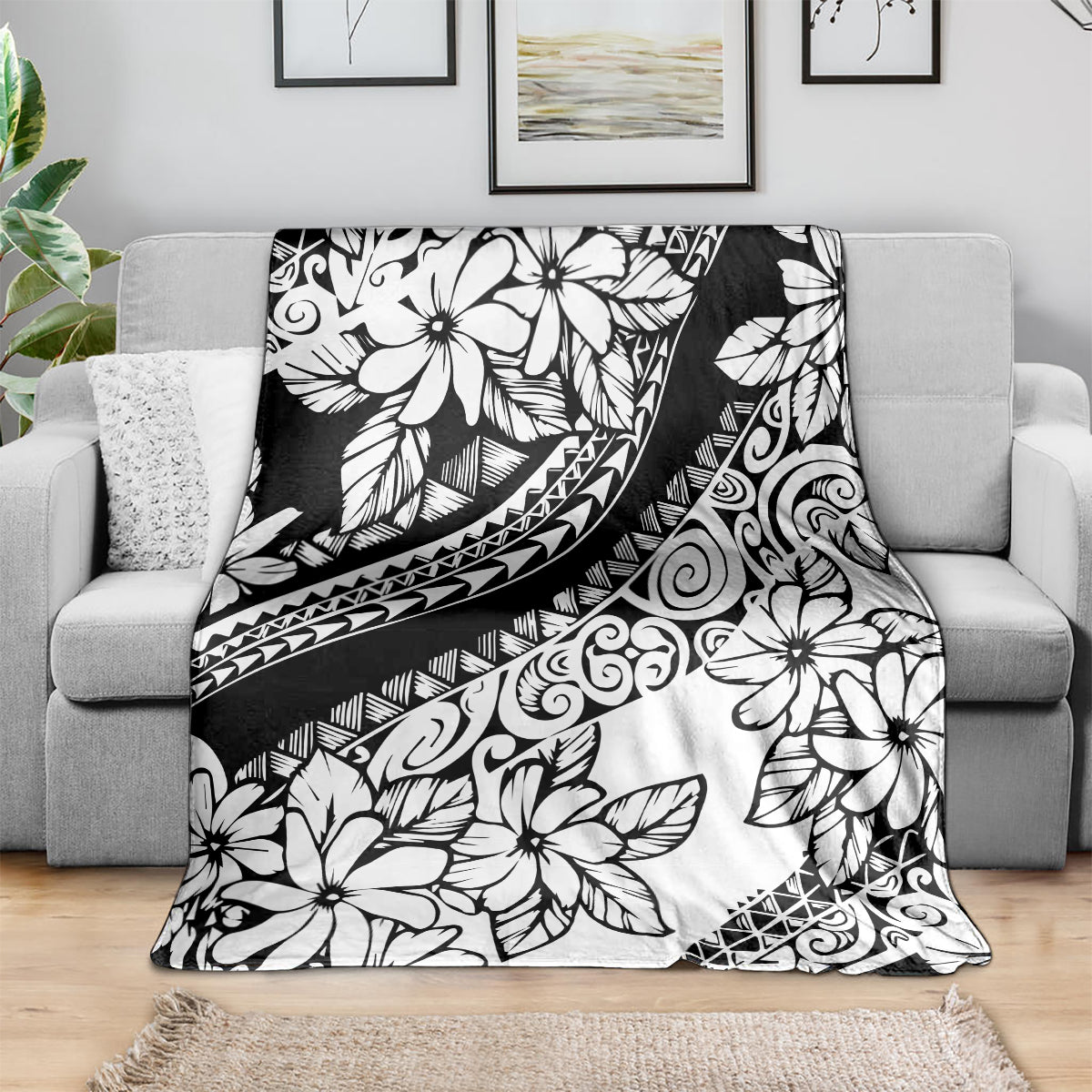 Black and white floral throw blanket with tribal motifs, draped across a sofa