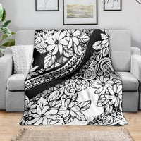 Black and white floral throw blanket with tribal motifs, draped across a sofa