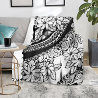 Black and white tropical flower blanket with decorative tribal border, draped on seat