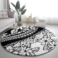 Black round carpet with bold white hibiscus-style flowers, swirls, and tribal motifs