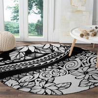 Black round carpet with white tropical leaves, flowers, and geometric border pattern
