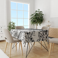 Black-and-white tropical flower tablecloth spread across dining table