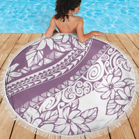 Purple round beach blanket with white tropical pattern and fringed border, spread out