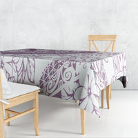 Purple and white floral tablecloth draped over dining table with matching pattern.