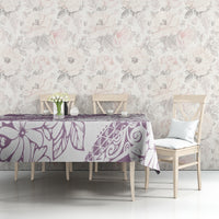 Purple floral tablecloth with botanical print, laid over a dining table.