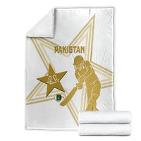 White Pakistan cricket blanket folded with gold star, player silhouette and Pakistan lettering