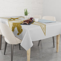 White tablecloth on dining table with gold cricket player and geometric corner design