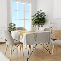White tablecloth on dining set with gold cricket logo print across the center