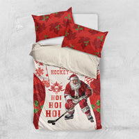 Red and white Christmas hockey bedding set laid flat on white surface, Santa and maple leaf pattern.
