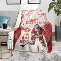 Red and white Santa hockey holiday blanket draped on a sofa with Merry Hockey-Mas print