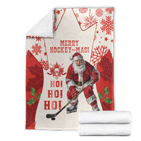 Red and white holiday hockey blanket with Santa ice hockey player, snowflakes, and stars