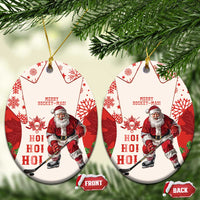 Red hockey-themed ceramic Christmas ornament with Santa and maple leaf pattern, oval shape