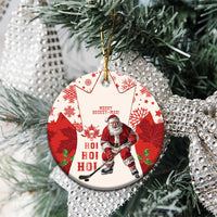 Red hockey-themed ceramic Christmas ornament with Santa and maple leaf pattern, circle close-up