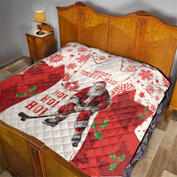Christmas hockey quilt on a bed in red and white with quilted diamonds, Santa and maple leaves