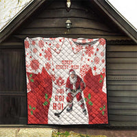 Christmas hockey quilt hanging on a wall in red and white with maple leaves, snowflakes, Santa
