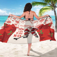 Red and white sarong beach wrap showing Santa hockey and “Merry Hockey-Mas”