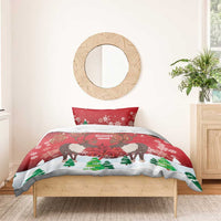 Christmas bedding set with red caribou and maple leaf print, shown on bed.
