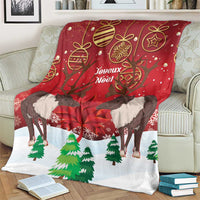 Christmas blanket with caribou, maple leaf, ornaments, and Joyeux Noel design