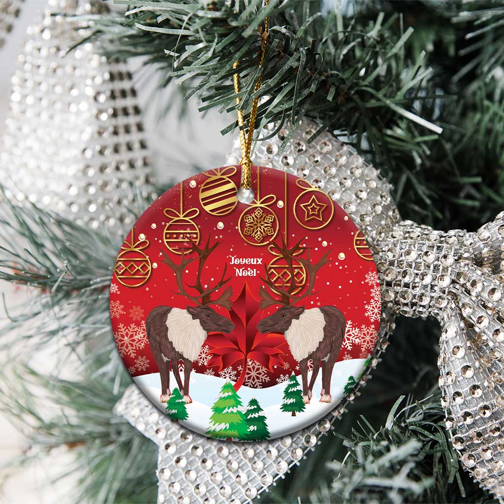 Red round ceramic Christmas ornament with caribou scene, hanging from Christmas tree