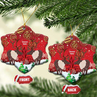 Red ceramic bell-shaped ornament with caribou scene, gold hanging loop, front/back labels